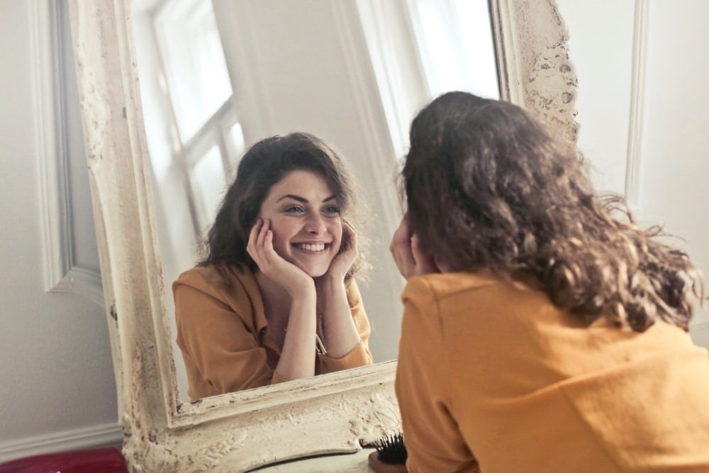 lady smiling at herself in mirror